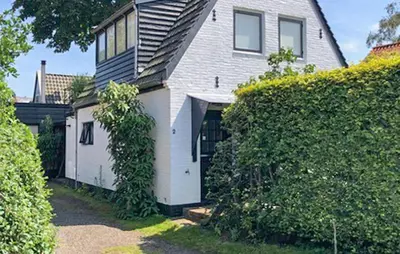 a white house with a gate and a hedge at Paradis in Bergen