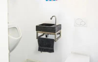 a bathroom with a sink and a toilet and a urinal at Paradis in Bergen