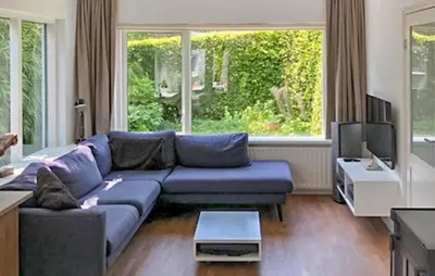 a living room with a blue couch and a tv at Paradis in Bergen