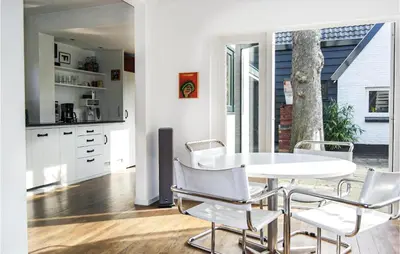 a white dining room with a table and chairs at Paradis in Bergen