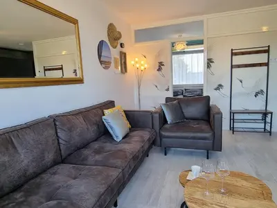 a living room with a couch and a table at De Schelp 73 the perfect place! in Zandvoort