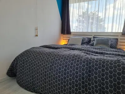 a large bed in a bedroom with a large window at De Schelp 73 the perfect place! in Zandvoort