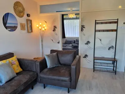 a living room with two couches and a mirror at De Schelp 73 the perfect place! in Zandvoort