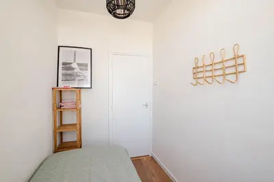 a white room with a bed and a shelf at Amsterdam Beach Apartment 1, Private Garden in Zandvoort