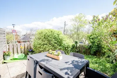 a table with a box of flowers on a patio at Amsterdam Beach Apartment 1, Private Garden in Zandvoort