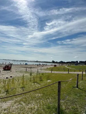 a group of people on a beach with a fence at 99 Lifestyle Suite in Zwaag