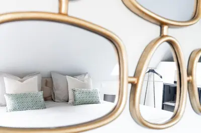 a mirror in front of a bed with pillows at 99 Lifestyle Suite in Zwaag