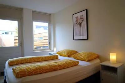 a bedroom with two beds and a window at Noordzee in Egmond aan Zee