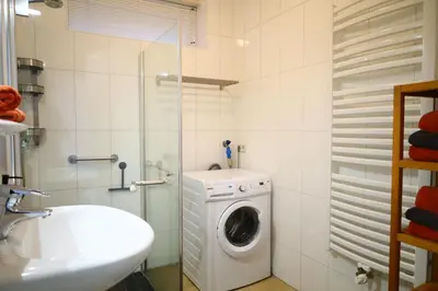 a bathroom with a washing machine and a sink at Noordzee in Egmond aan Zee