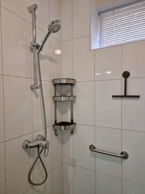 a shower with a shower head in a bathroom at Noordzee in Egmond aan Zee