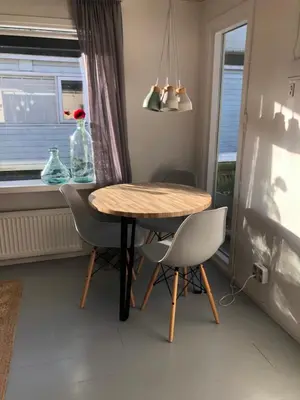 a dining room with a table and chairs and a window at Houseboat apartment with water terrace, free bikes & fast wifi in Amsterdam