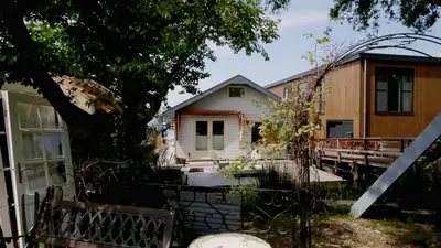 a group of houses in a yard with a tree at Houseboat apartment with water terrace, free bikes & fast wifi in Amsterdam