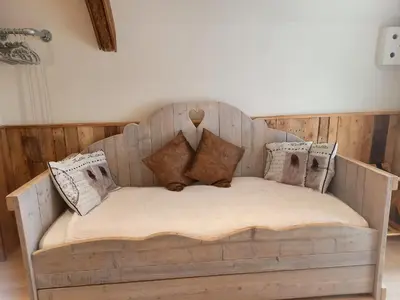 a wooden bed with pillows on it in a room at Pura Vida Panorama in Oud-Ade