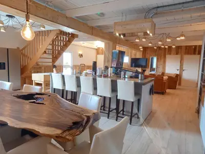 a dining room with a wooden table and white chairs at Pura Vida Panorama in Oud-Ade