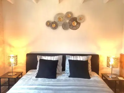 a bedroom with a bed with two lamps and two mirrors at Pura Vida Panorama in Oud-Ade