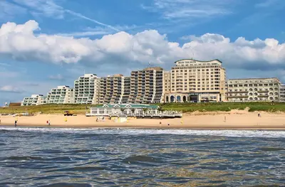 a beach in front of a city with tall buildings at Pura Vida Panorama in Oud-Ade