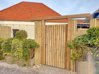 a wooden fence in front of a house at Pura Vida Panorama in Oud-Ade