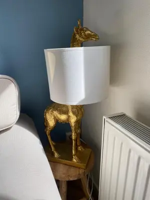 a lamp with a gold horse on a table next to a bed at ‘T Vissershuisje in Zandvoort