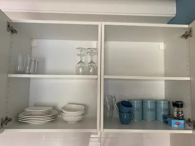 a white cabinet with plates and dishes in it at ‘T Vissershuisje in Zandvoort