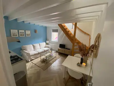 a living room with a white couch and blue walls at ‘T Vissershuisje in Zandvoort
