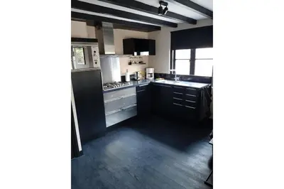 a kitchen with black cabinets and a black refrigerator at Zomerhuis Adriana in Egmond aan Zee