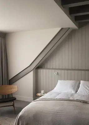 a bedroom with a bed and a chair at Boutique Hotel Benedict Noordwijk in Noordwijk aan Zee