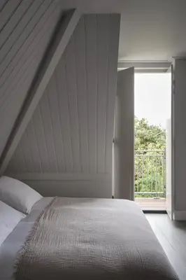 a bedroom with a bed and a large window at Boutique Hotel Benedict Noordwijk in Noordwijk aan Zee