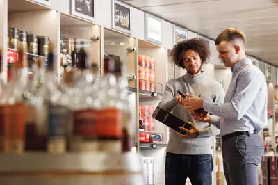 two men standing in a store looking at a book at DFDS Mini Cruise Amsterdam - Newcastle - Amsterdam in IJmuiden