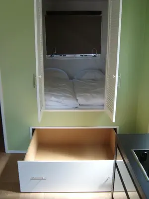 a cabinet with a bed inside of it at Luxe Strandhuisje op het strand van Wijk aan Zee met wifi in Wijk aan Zee