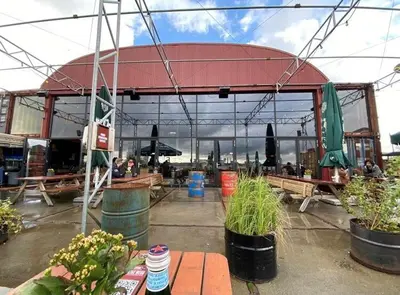 a pavilion with tables and plants in front of a building at B&B Twiske Zuid, Amsterdam free parking in Amsterdam