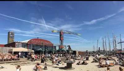 a group of people sitting on the sand at the beach at B&B Twiske Zuid, Amsterdam free parking in Amsterdam