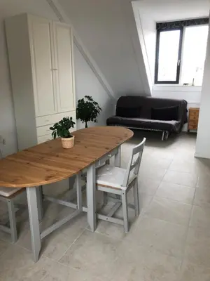 a wooden table and chairs in a living room at B&B Twiske Zuid, Amsterdam free parking in Amsterdam