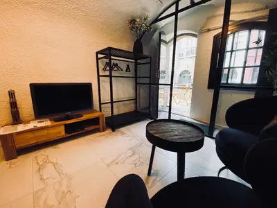 a living room with a television and a table at Slapen onder de Dom in Utrecht