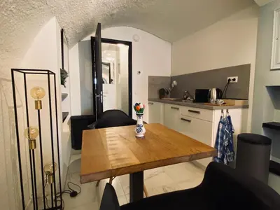 a small kitchen with a wooden table and chairs at Slapen onder de Dom in Utrecht
