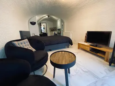 a bedroom with a bed and a tv and a couch at Slapen onder de Dom in Utrecht