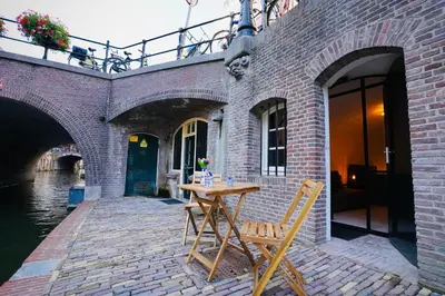 a wooden table and chair in front of a brick building at Slapen onder de Dom in Utrecht