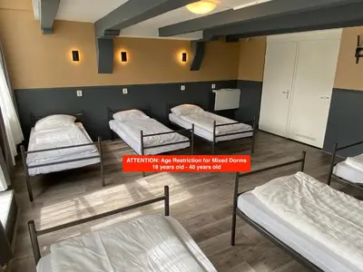 a room with three beds and a sign that reads migration fees reimbursement for hired rooms at Xplore Hostel Amsterdam in Amsterdam
