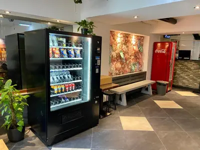 a soda machine in a store with drinks in it at Xplore Hostel Amsterdam in Amsterdam