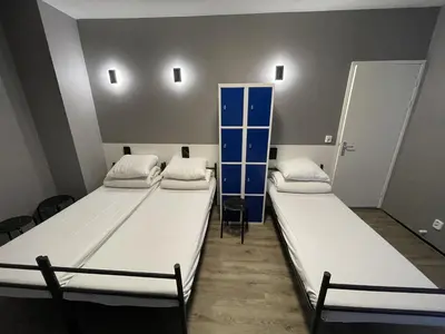a room with two beds and a shelf in it at Xplore Hostel Amsterdam in Amsterdam