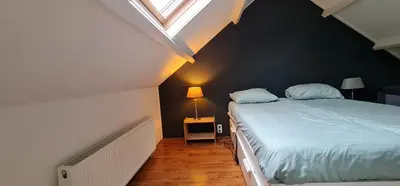 a bedroom with a large bed with a window at Ferienhaus Abenteuer in Egmond aan Zee