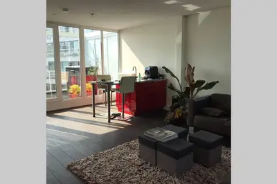 a living room with a table and a couch at Large and cosy house on the water: free Parking in Amsterdam