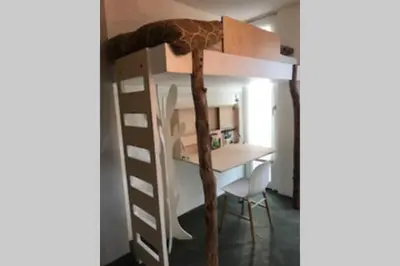 a bunk bed with a desk in a room at Large and cosy house on the water: free Parking in Amsterdam