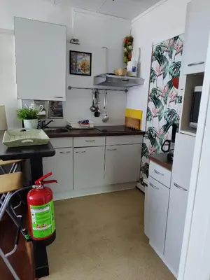 a kitchen with white cabinets and a red fire hydrant at Cosy appartement Wassenaar in Wassenaar