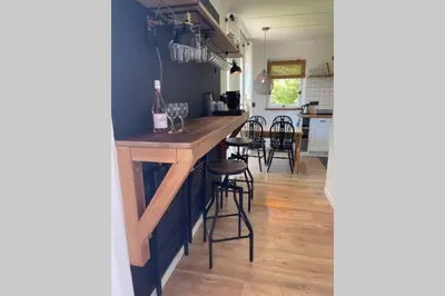 a kitchen with a bar with some wine glasses at Have a nice stay! - Raaff-71 sfeervol huis direct bij bos, duin en strand in Noordwijk