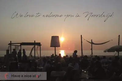 a group of people watching the sunset on the beach at Have a nice stay! - Raaff-71 sfeervol huis direct bij bos, duin en strand in Noordwijk