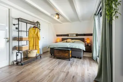 a bedroom with a bed and a rack of clothes at Zandvoort-17 in Zandvoort