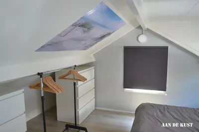 a attic bedroom with a bed and a tv at Zomerhuis 