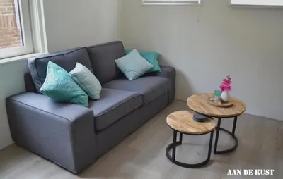 a living room with a couch and two tables at Zomerhuis 