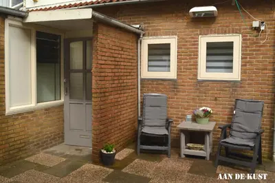 two chairs and a table in front of a brick building at Zomerhuis 