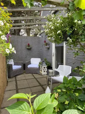 a patio with chairs and a table and a pergola at Gartenblick in Zandvoort